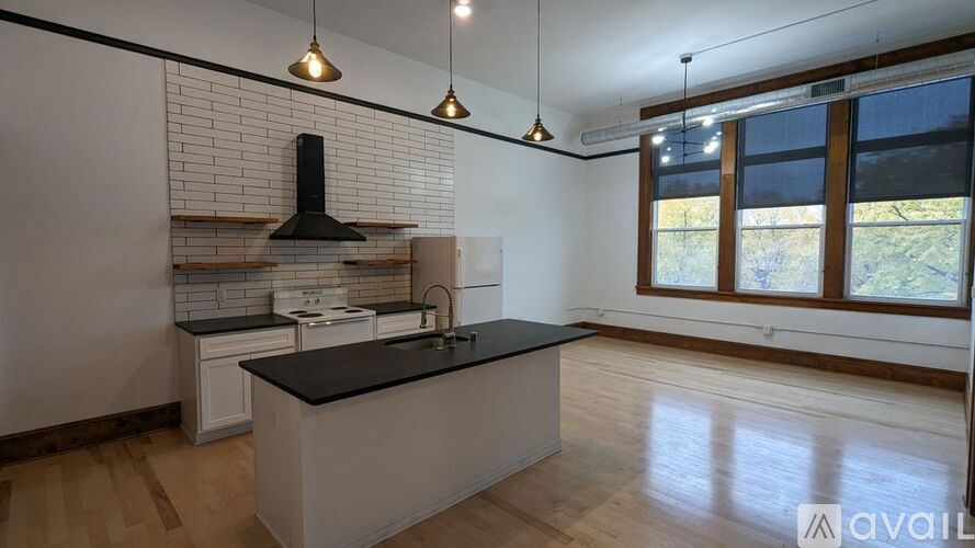 A kitchen with a black countertop and white cabinets.