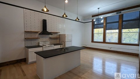 A kitchen with a black countertop and white cabinets.