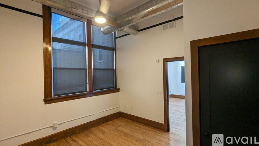 A room with a window and a door is available for rent.