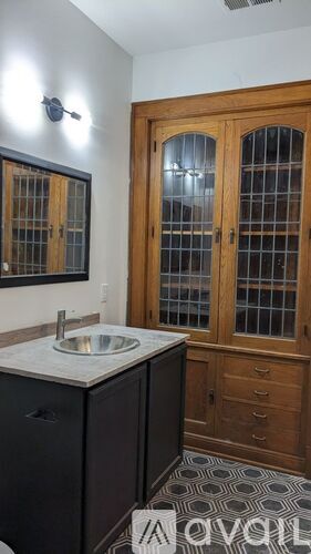 A bathroom with a sink, toilet, and a cabinet.