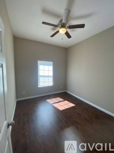 A room with a ceiling fan and a window.