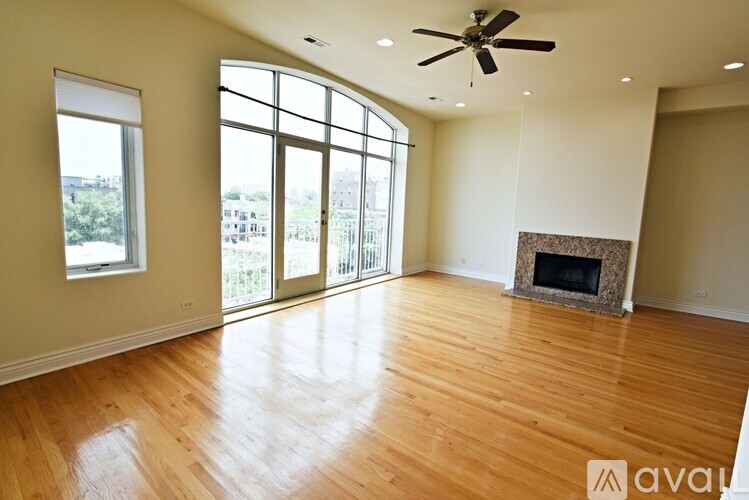 A spacious room with a fireplace and a ceiling fan.