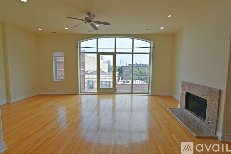 A spacious room with a fireplace and a ceiling fan.