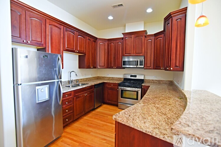 A kitchen with wooden cabinets and granite countertops.