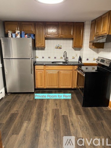 A kitchen with wooden cabinets and a refrigerator.
