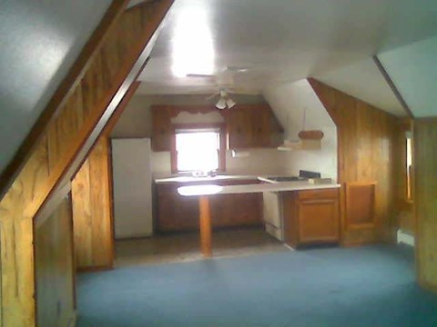 A kitchen with wooden cabinets and a window.