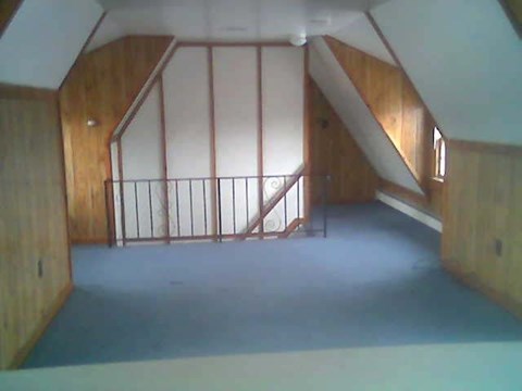 A room with a staircase and wooden walls.