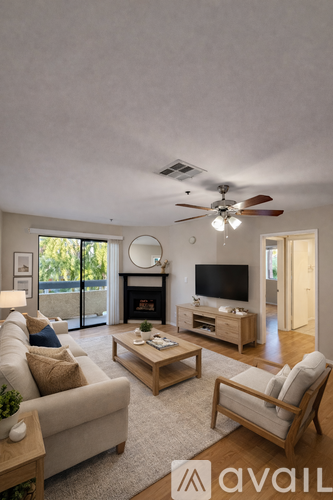 A living room with a fireplace, a couch, a chair, and a television.