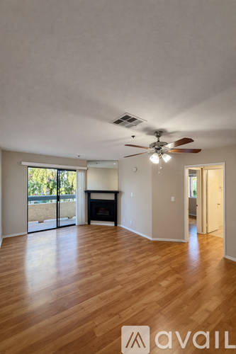 A room with wooden floors and a ceiling fan.