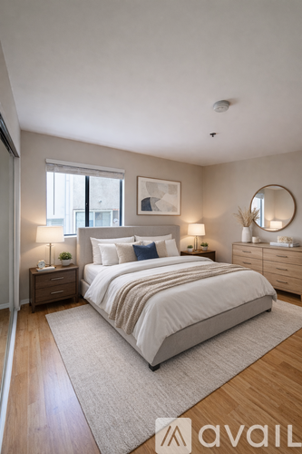 A bedroom with a large bed, a nightstand with a lamp, and a dresser with a mirror.