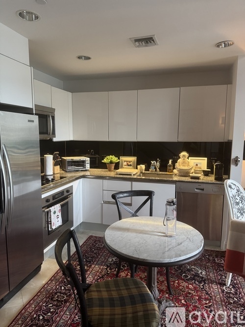 A kitchen with a table and chairs in the middle.