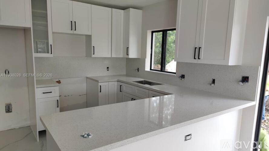 A modern kitchen with white cabinets and a large island.