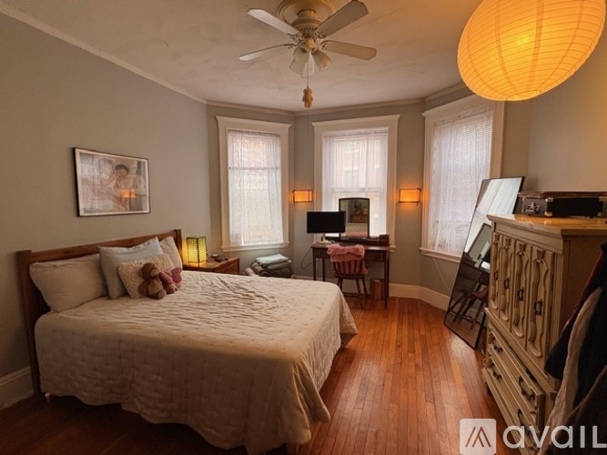 A bedroom with a large bed and a ceiling fan.