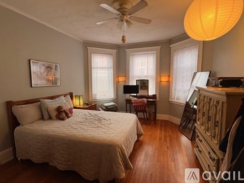 A bedroom with a large bed and a ceiling fan.
