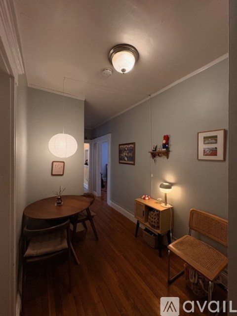 A living room with a table, chairs and pictures on the wall.