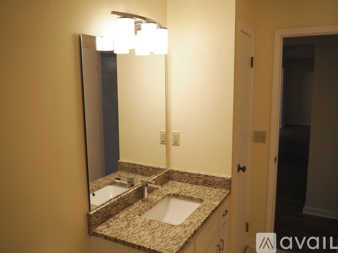 A bathroom with a granite countertop and a large mirror.