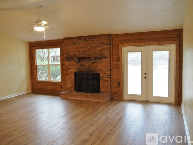 A room with a fireplace and wooden floors.