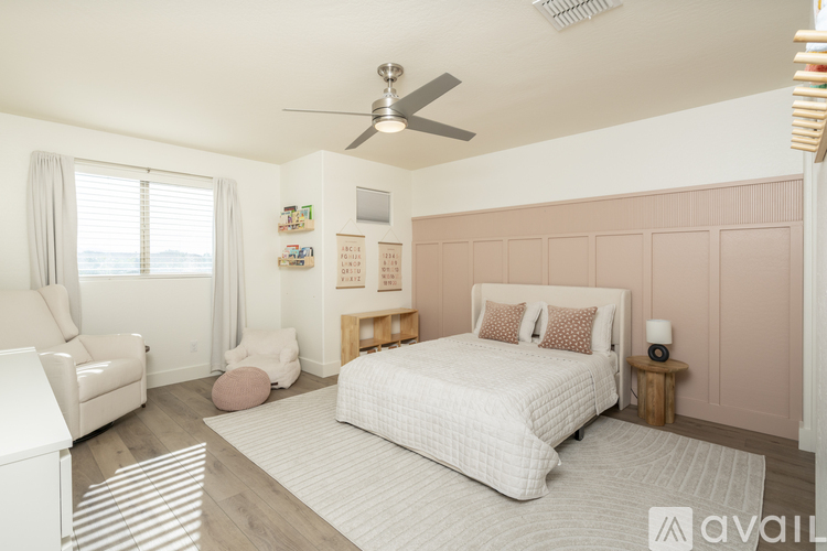 A bedroom with a large bed and a ceiling fan.