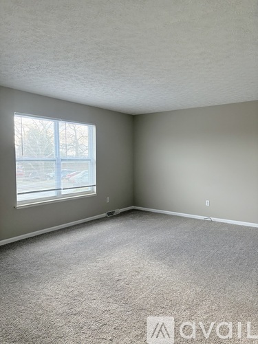 A car is visible through the window of the room.