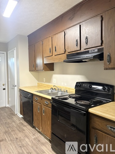 A kitchen with wooden cabinets and black appliances.