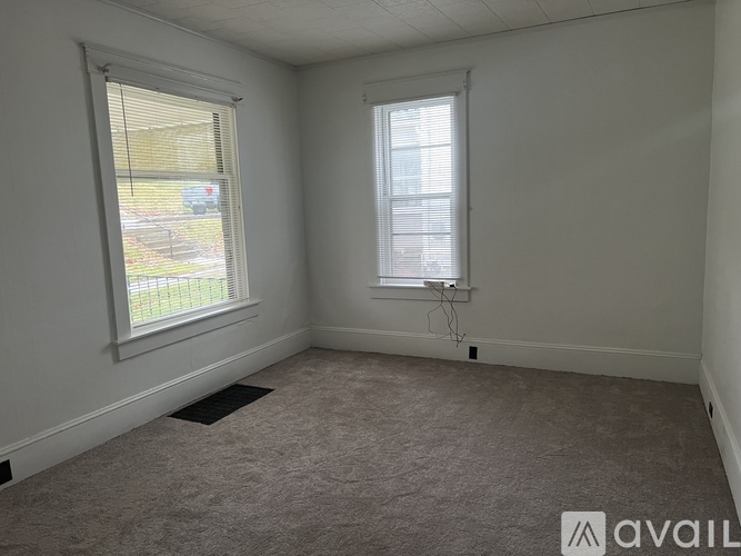 A room with a window and a car parked outside.