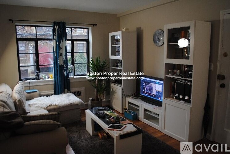 A living room with a couch, a coffee table, and a television.