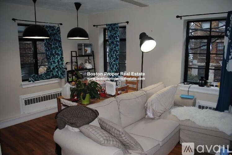 A living room with a white couch and a wooden coffee table.
