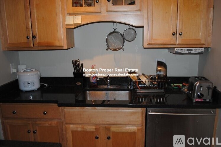 A kitchen with wooden cabinets and a black countertop.