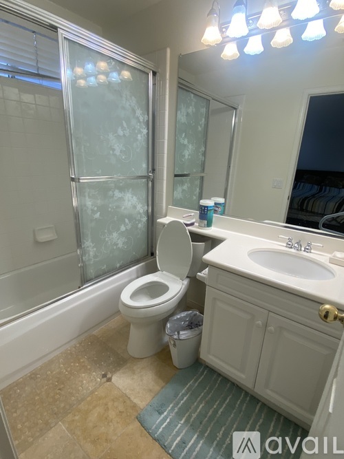 A bathroom with a toilet, sink, and frosted glass shower door.