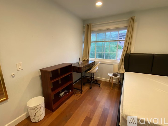 A room with a desk and chair and a mirror.