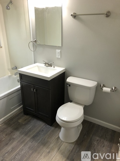 A bathroom with a white toilet and a black cabinet.