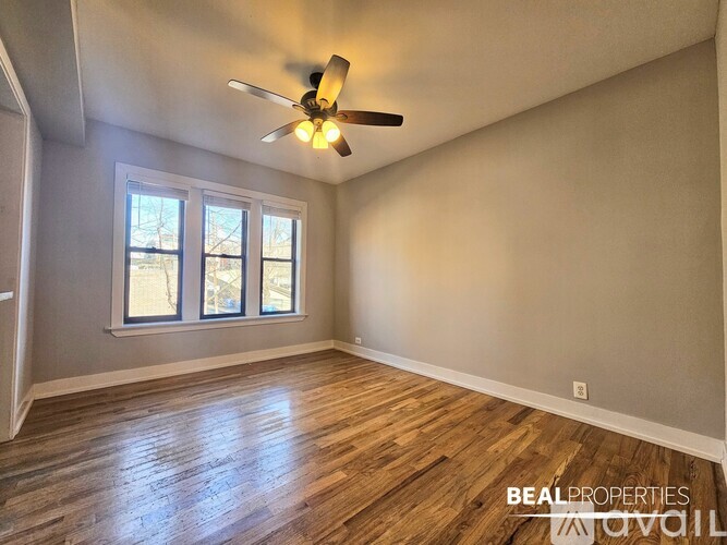 A room with a ceiling fan and wooden flooring.