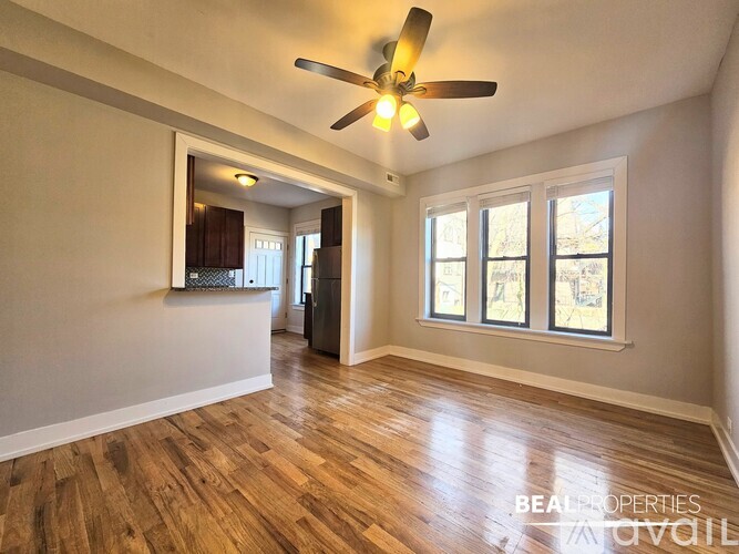 A spacious room with a ceiling fan and wooden flooring.