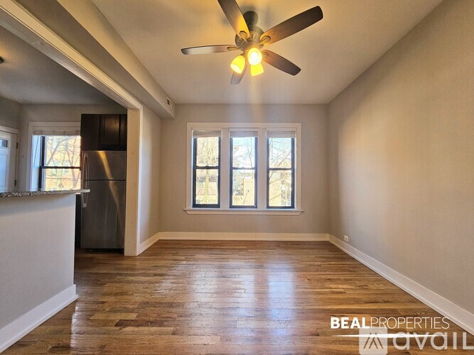 A room with a ceiling fan and wooden flooring.