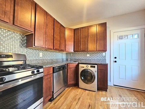 A kitchen with wooden cabinets and a stainless steel dishwasher.