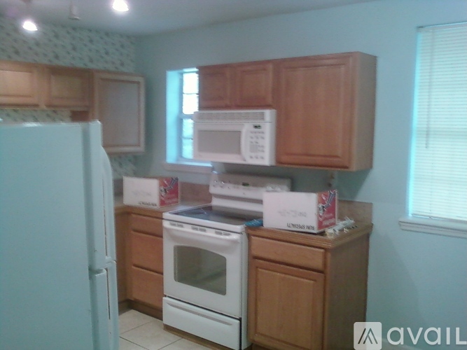 A kitchen with a white fridge, a white microwave, and a white oven.