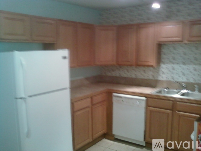 A kitchen with a white refrigerator and a washing machine.