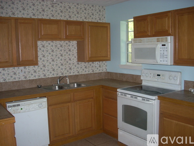 A kitchen with wooden cabinets and a white dishwasher.