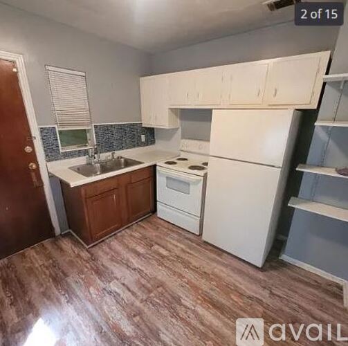 A kitchen with white appliances and wooden floors.