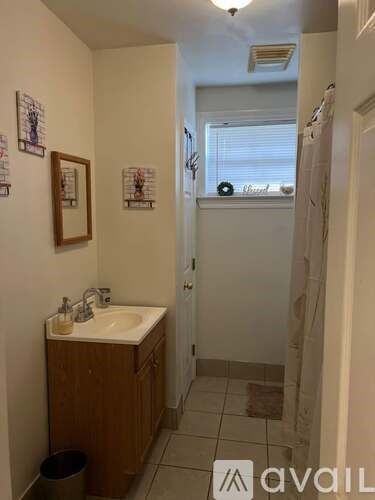 A bathroom with a sink, mirror, and toiletries.