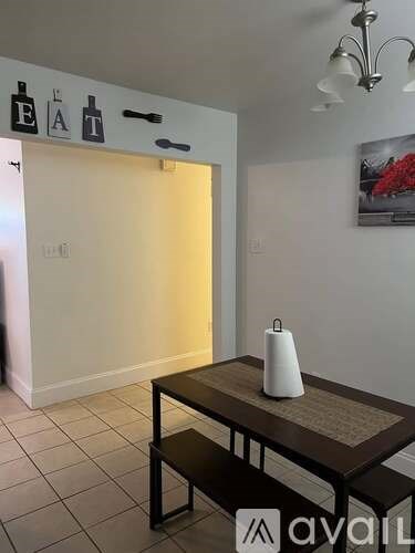 A dining table with a white vase on it in a room.