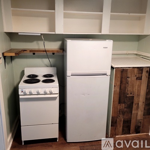 A white stove and refrigerator in a small kitchen.