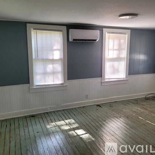 A room with a window and a wall-mounted air conditioner unit.