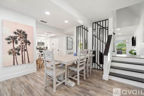 A dining room with a wooden table and chairs.