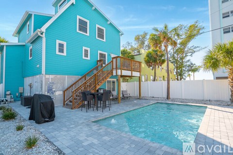 A blue house with a pool in the backyard.