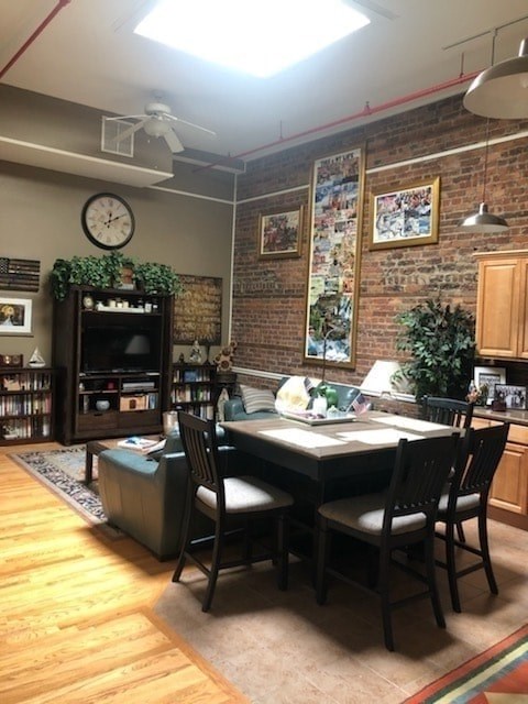 A dining room with a brick wall and a wooden table.
