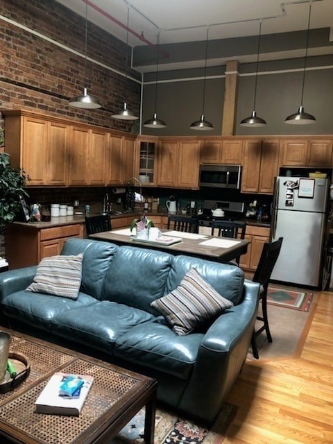 A blue couch sits in a kitchen with wooden cabinets and a refrigerator.