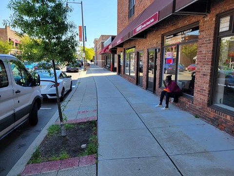 A man is sitting on a bench outside of a store.