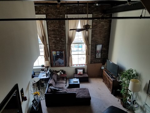 A living room with a brick wall and a couch.