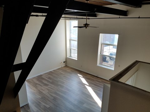 A room with wooden floors and a ceiling fan.